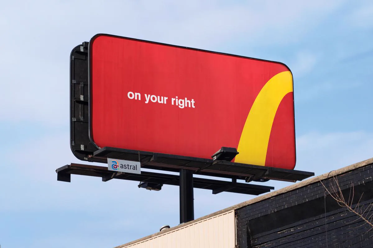 Outdoor do McDonald's com os arcos dourados formando uma curva para a direita e a frase on your right