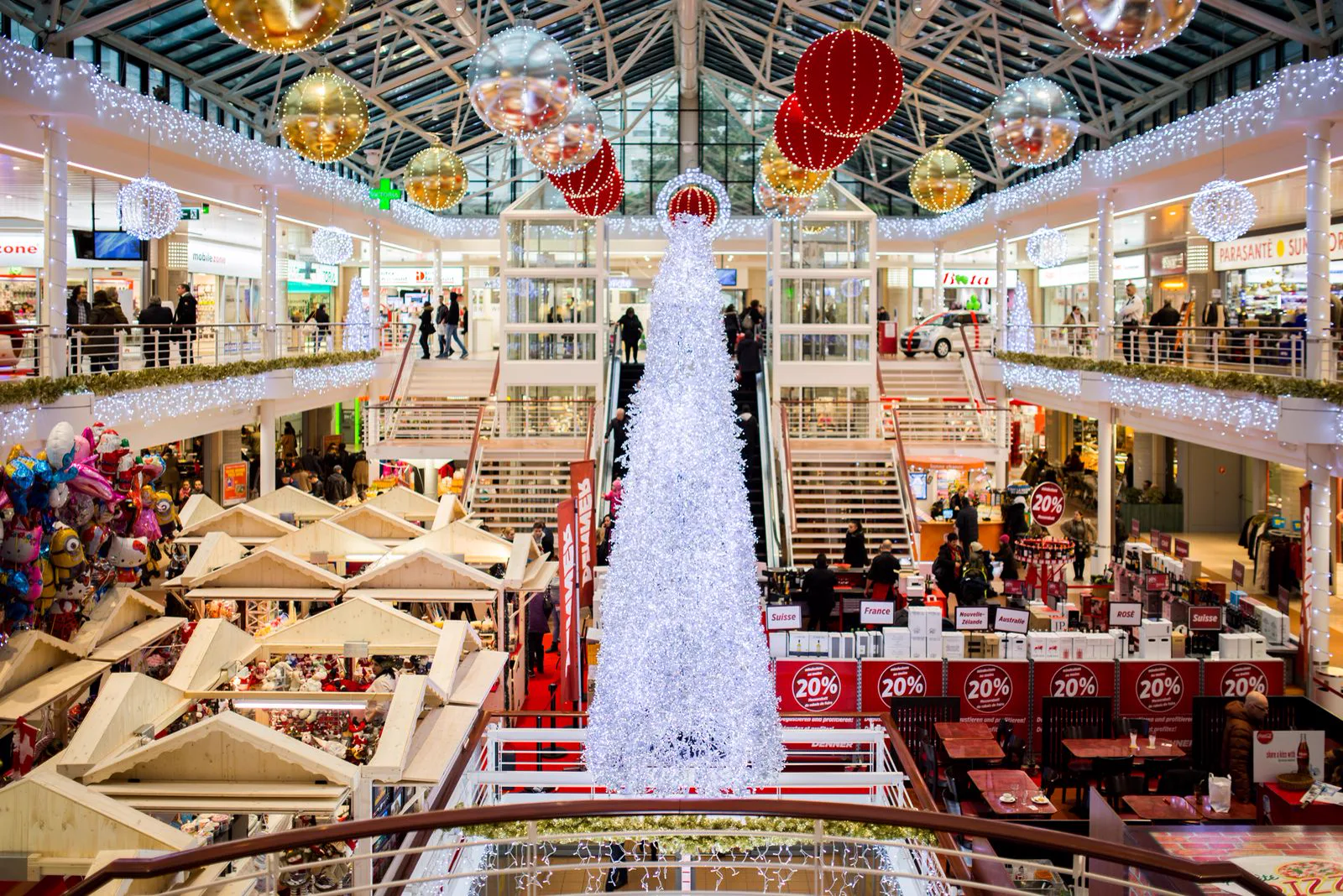 Shopping cheio com uma grande árvore de Natal e lojas em promoção