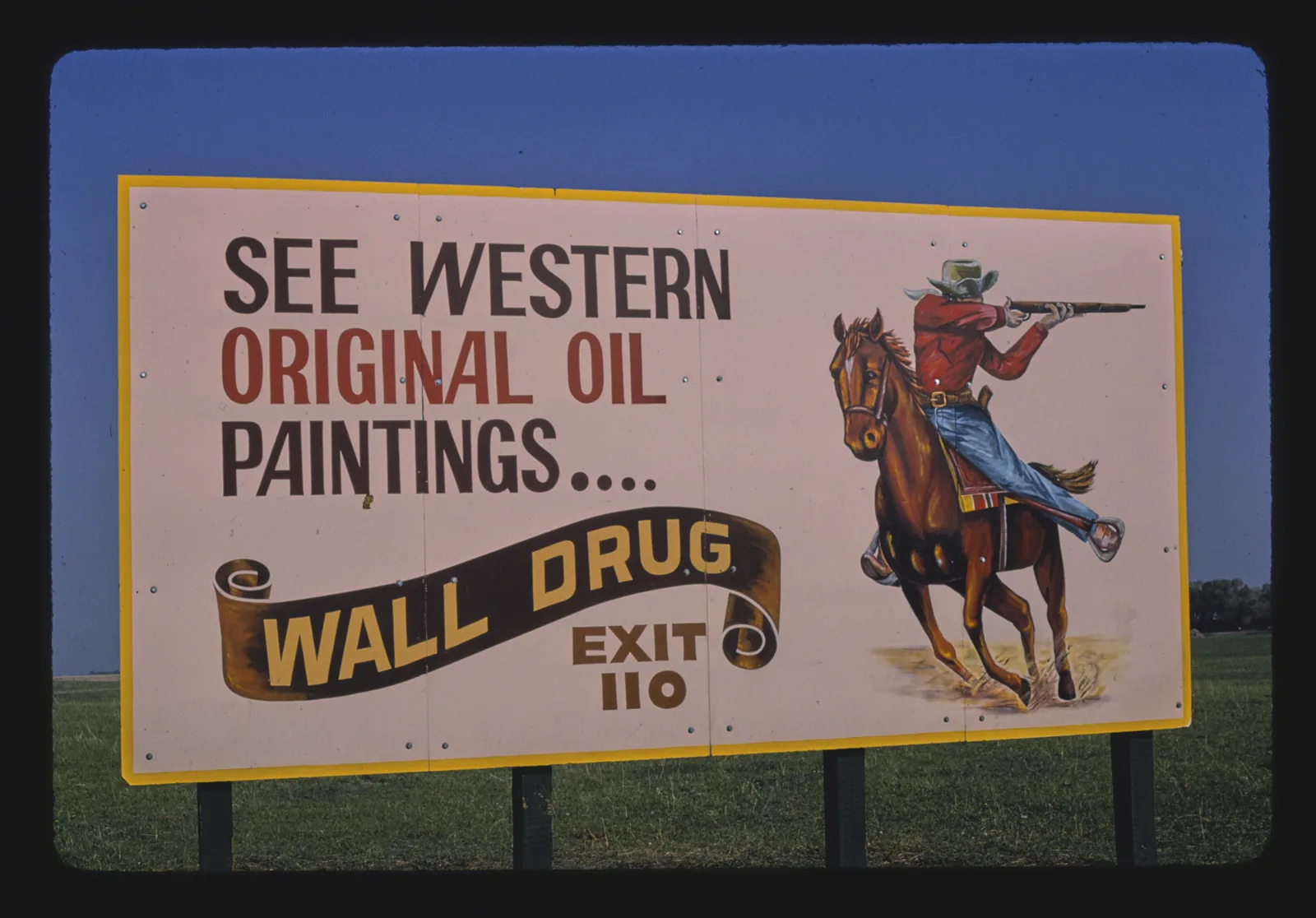 Outdoor antigo da Wall Drug na rodovia I-90 anunciando pinturas do Velho Oeste e a saída 110